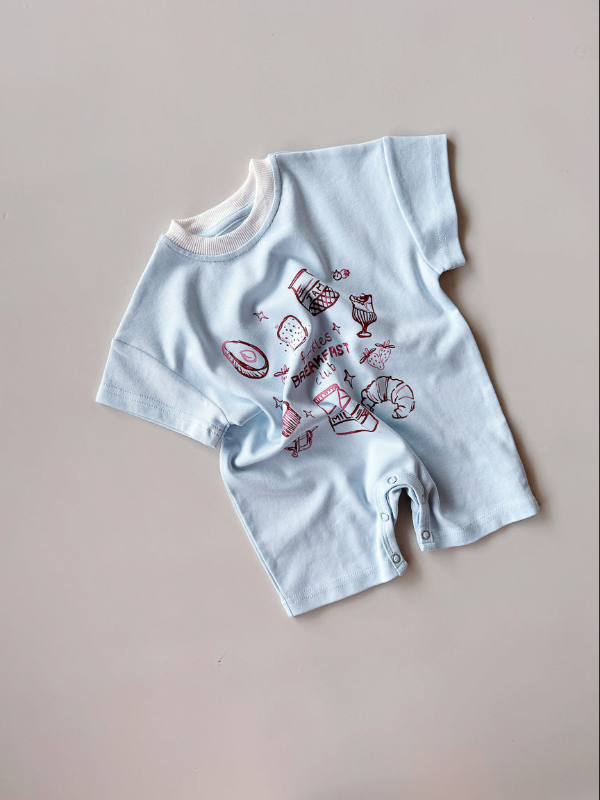 Light blue baby romper with red and pink designs on a beige background